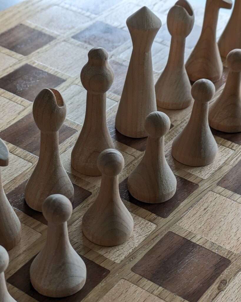 Wooden game pieces standing on a checkered wooden game board