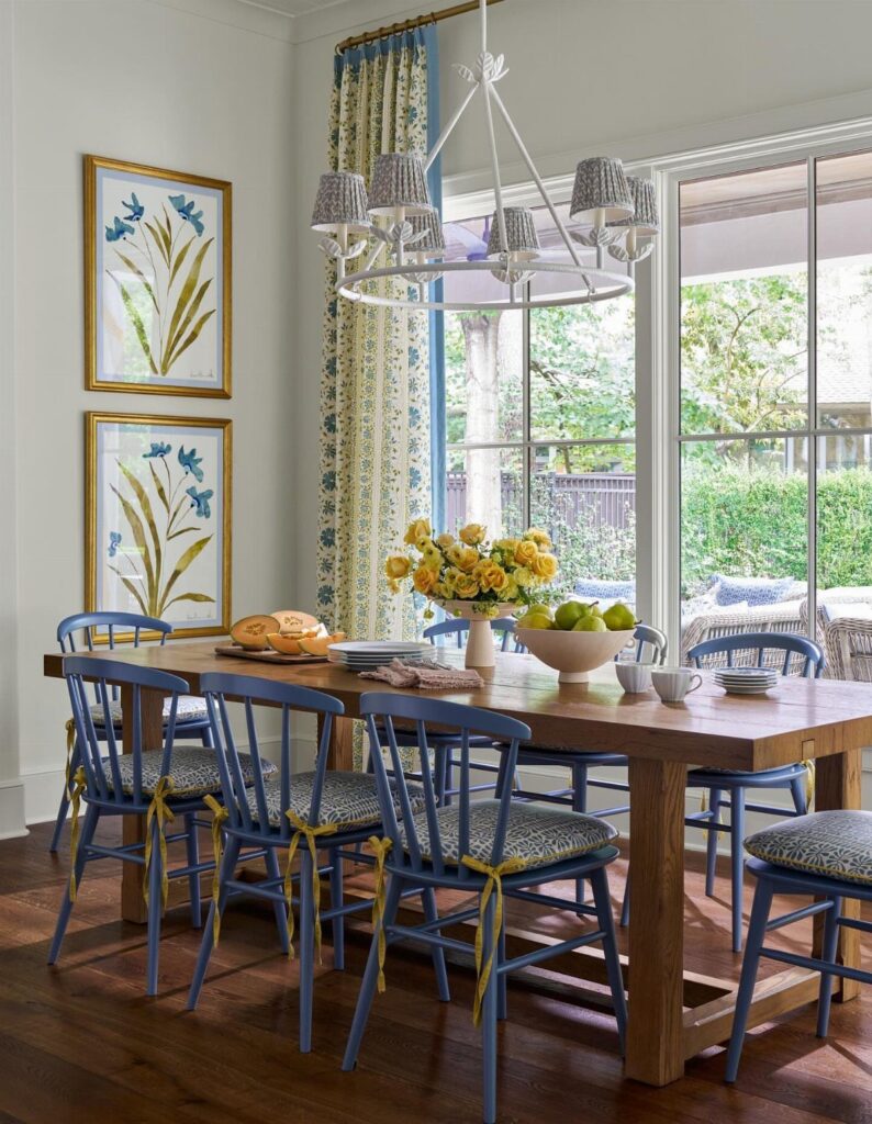 Blue dining chairs with patterned upholstered seats around a rustic wooden table.