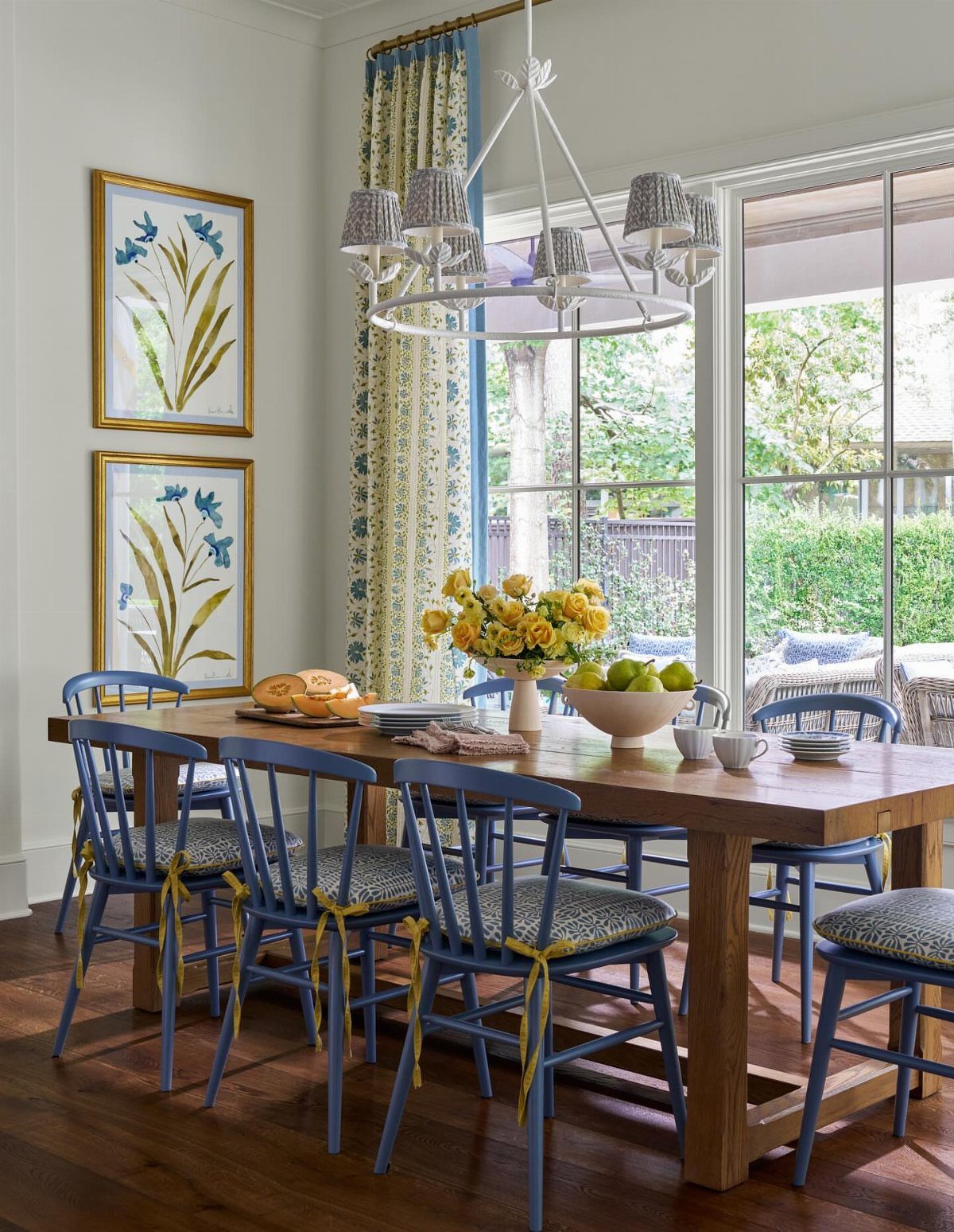 Blue dining chairs with patterned upholstered seats around a rustic wooden table.