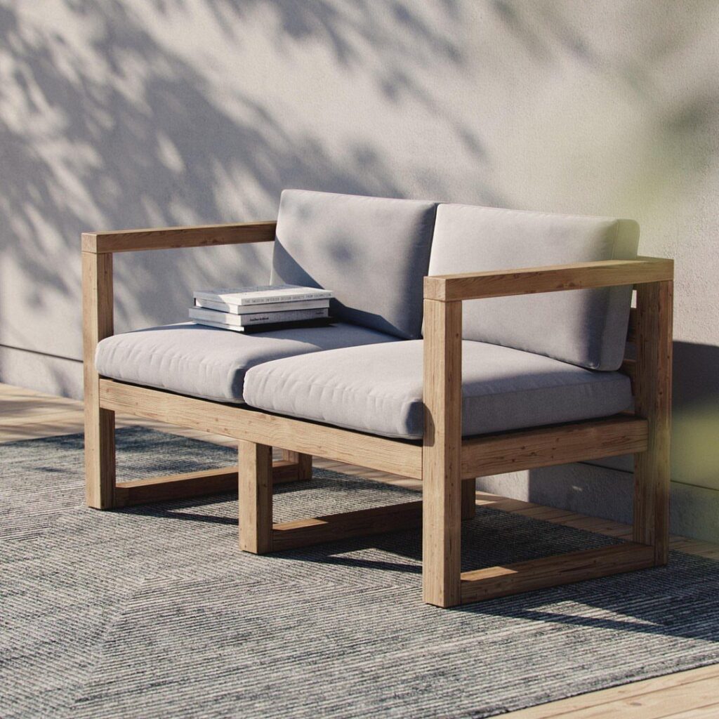 Modern wooden lounge chair with grey cushions and books on the armrest
