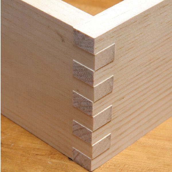 Interlocking finger joints on the corner of a light-colored wooden box.