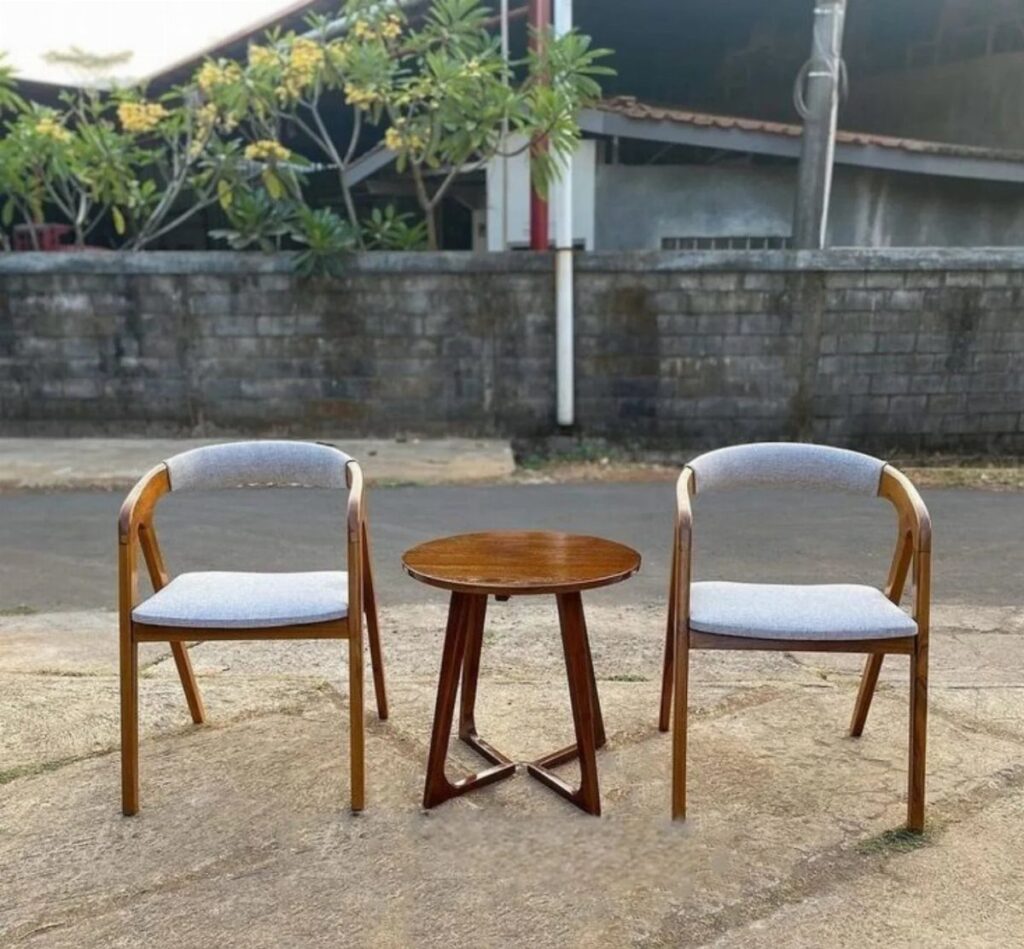 Two wooden armchairs with grey cushioned seats and a small round wooden table.