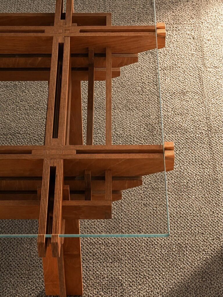 Japanese joinery coffee table with interlocking wooden beams and a clear glass top