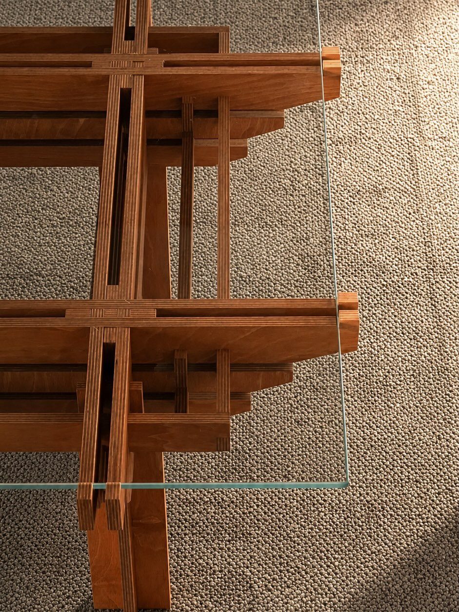 Japanese joinery coffee table with interlocking wooden beams and a clear glass top