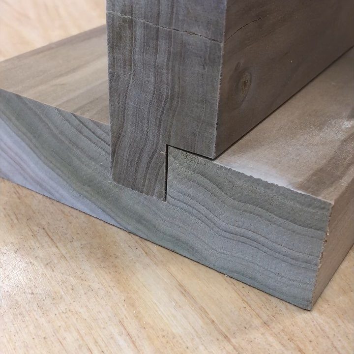 Wooden boards joined with a dado joint, showing a vertical piece in a groove.