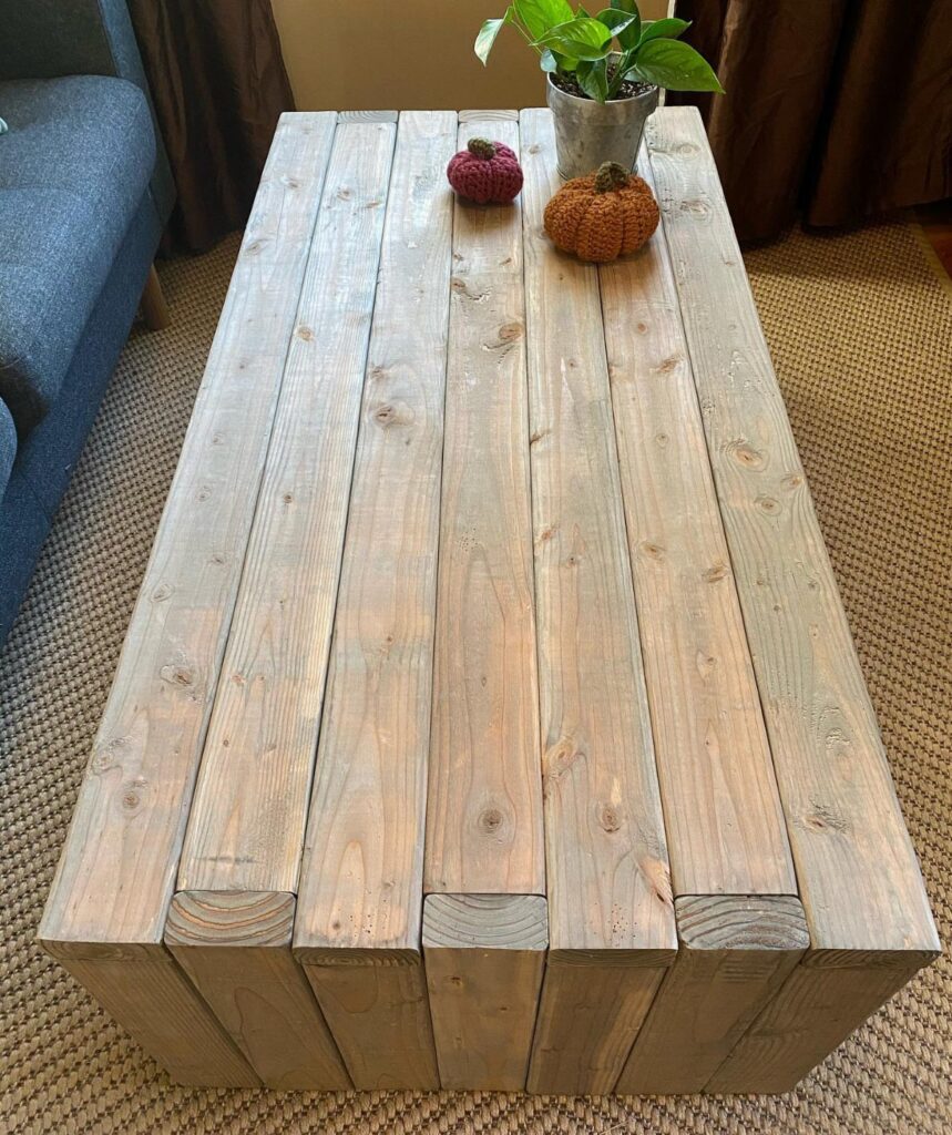 Rustic pallet wood coffee table with small decorative pumpkins and a potted plant