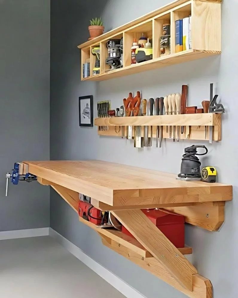 Wooden wall-mounted compact workbench with tool storage and a red toolbox underneath.
